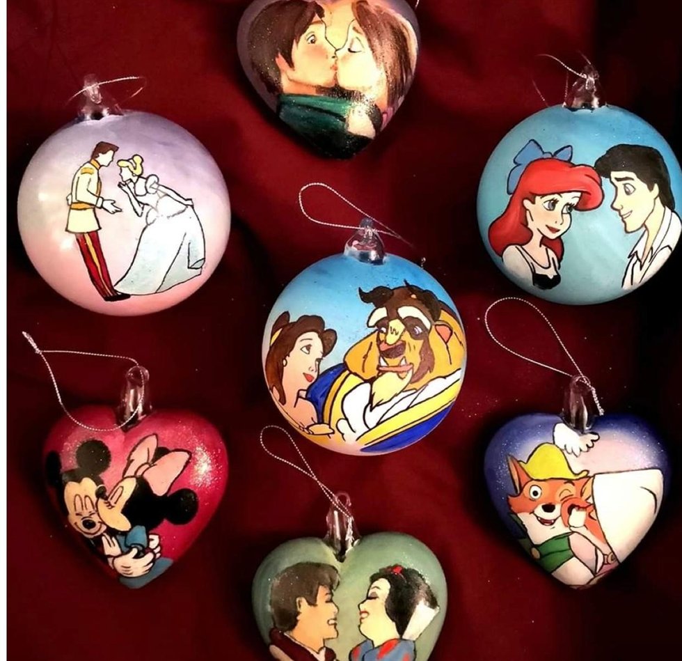 Sfere e cuori di Natale dipinti a mano con coppie di personaggi dei cartoni animati