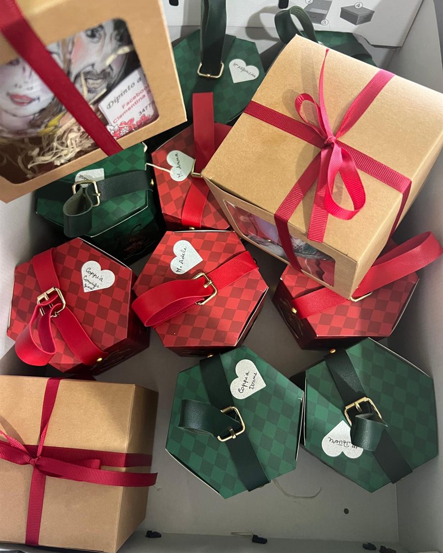 Pacchetti regalo pronti per la spedizione, incartati con nastri rossi e verdi